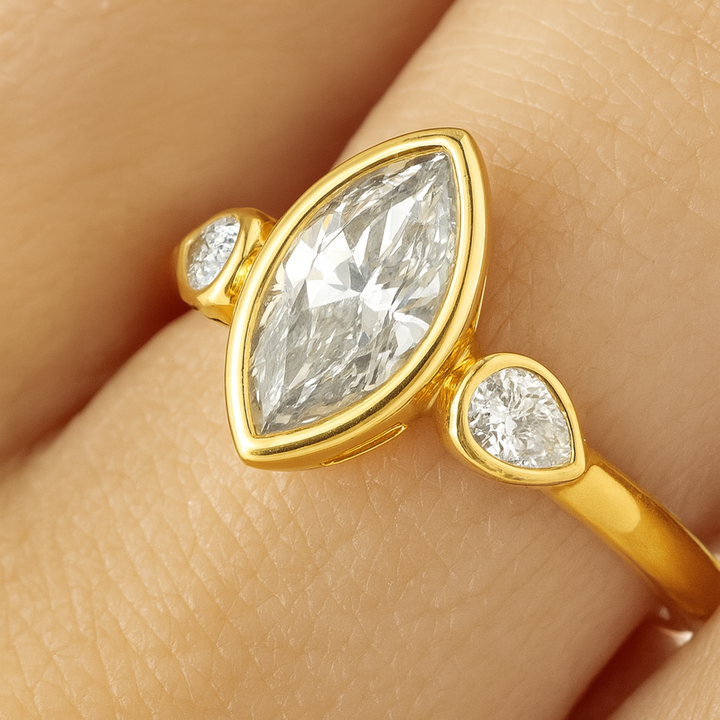 1.5 Carat Marquise Lab Diamond Engagement Ring with Pear Accents and Bezel Setting, Close Up on Finger 3 Stone Style | Rare Earth Jewelry