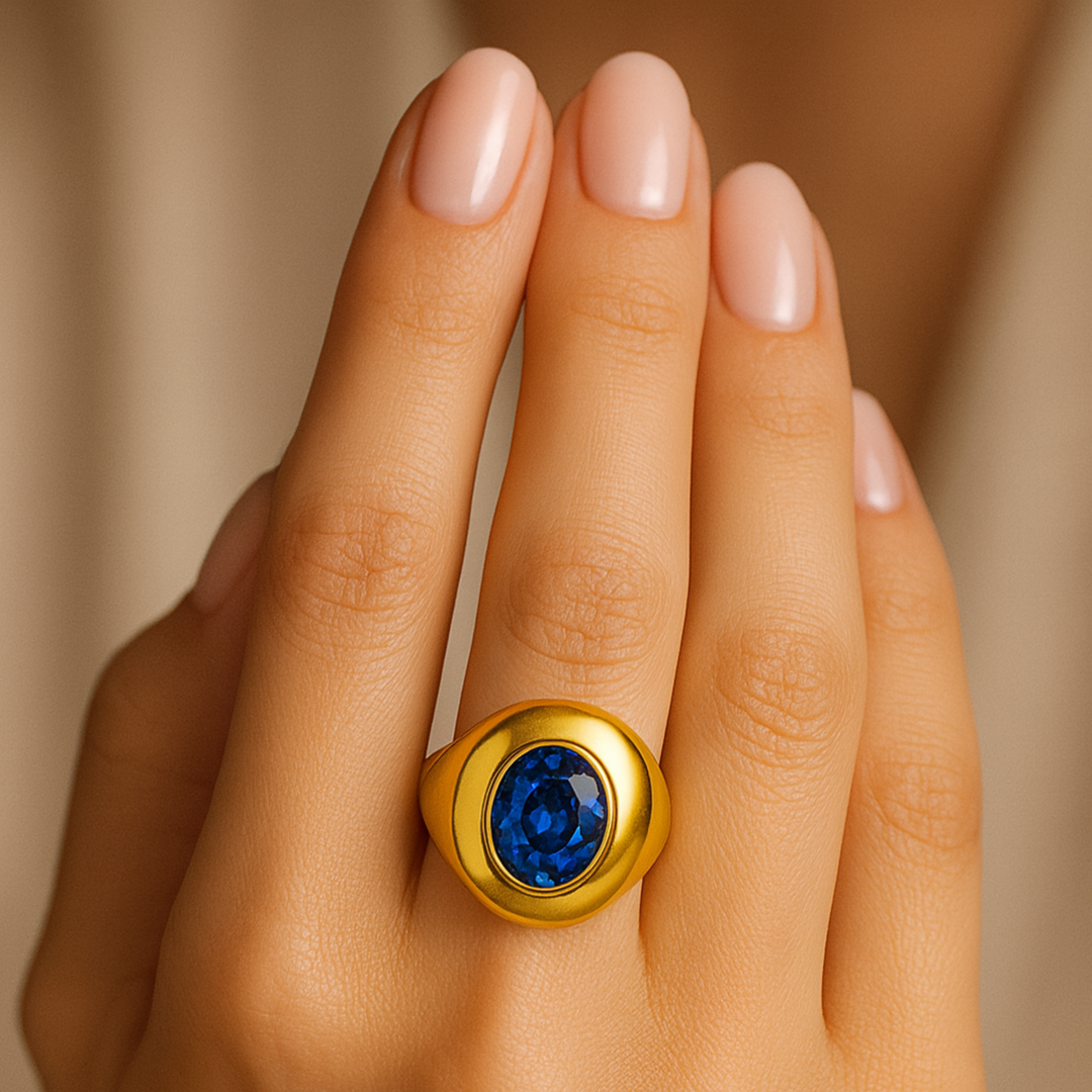 Close up of large oval blue sapphire dome ring on the finger, blue stone statement ring, sapphire cocktail ring, bold bezel set sapphire ring in 14K or 18K Gold | Rare Earth Jewelry
