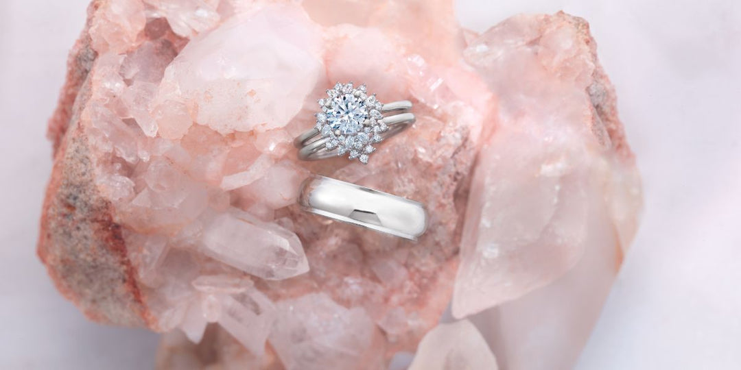 Ready-to-ship diamond wedding set and men’s band on rose quartz crystal. Shop handcrafted jewelry from Rare Earth Jewelry.