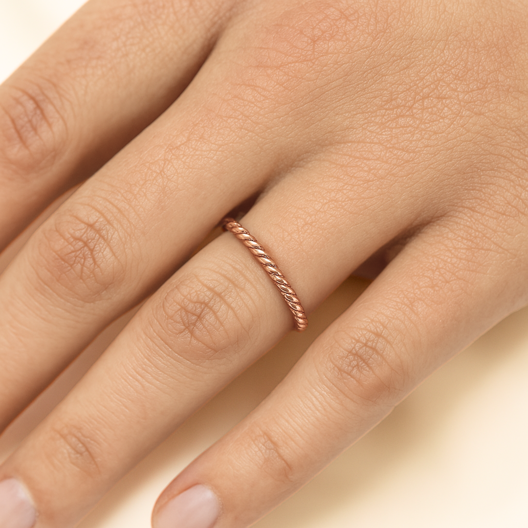 A thin rope design band in rose gold shown on the hand, dainty stackable band or wedding ring in 14K or 18K Gold | Rare Earth Jewelry