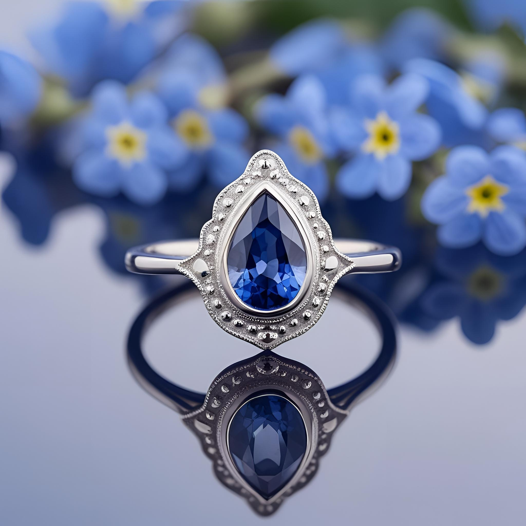 Pear cut blue sapphire bezel set ring with decorative beaded detailing, vintage-inspired design | Antique Style Custom Engagement Rings | Rare Earth Jewelry