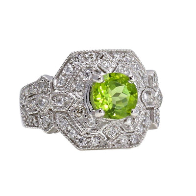 A large Art Deco style statement ring with a round natural Peridot and pave set diamonds.  This vintage style Peridot ring has a unique geometric design and milgrain beaded edge details from Rare Earth Jewelry.