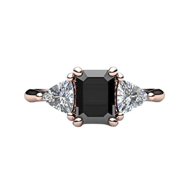 A black diamond engagement ring in a 3 stone style with an emerald cut natural black diamond and white sapphire trillions, shown here in rose gold from Rare Earth Jewelry.
