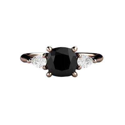 A three stone style black diamond engagement ring with a square cushion cut natural black diamond and pear cut diamond side stones, shown in rose gold from Rare Earth Jewelry.