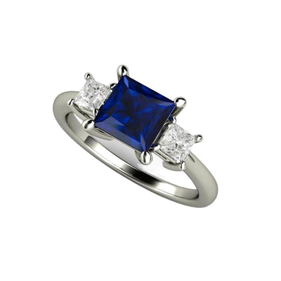 A princess cut square Blue Sapphire engagement ring in a 3 stone style with diamond side stones in gold or platinum from Rare Earth Jewelry.