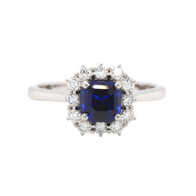 A Blue Sapphire engagement ring with a 1 carat asscher cut lab grown blue sapphire surrounded by a halo of natural diamonds in a vintage inspired cluster design from Rare Earth Jewelry.