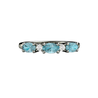 A oval blue zircon and diamond ring in gold or platinum.  The natural Blue Zircon is set east to west with natural diamonds in between.  A unique wedding ring or anniversary band with blue gemstones.