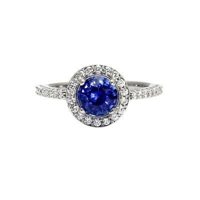 A round natural blue Sapphire engagement ring with a diamond halo design with pave set diamonds.  This sapphire ring has a natural sapphire from Ceylon, Sri Lanka with a lovely royal blue color from Rare Earth Jewelry.