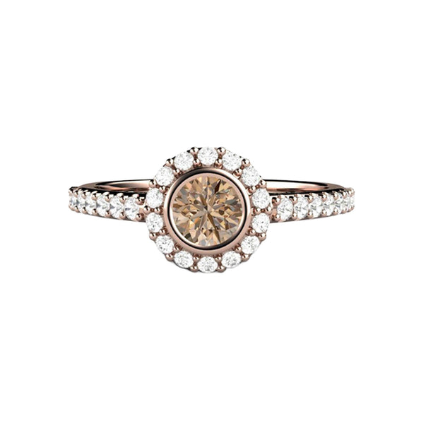 A petite and feminine engagement ring with a cognac colored dark brown natural diamond in a round bezel setting with pave diamond halo and accented shank, shown in rose gold, from Rare Earth Jewelry.