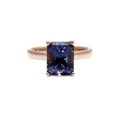 A classic solitaire engagement ring with a large emerald cut color change sapphire. This unique sapphire ring changes from blue to purple and pink with flashes of teal.  Shown in rose gold. Available exclusively from Rare Earth Jewelry.