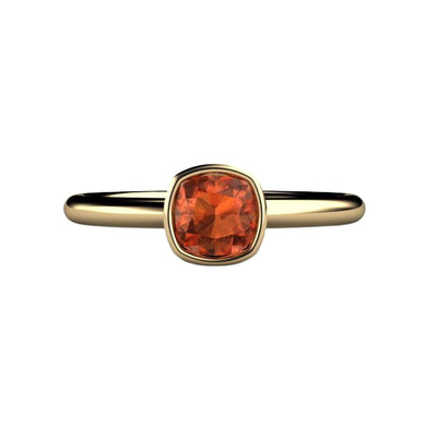 A simple Orange Sapphire bezel set ring in minimalist style cushion cut solitaire engagement ring on a plain band in gold or platinum.