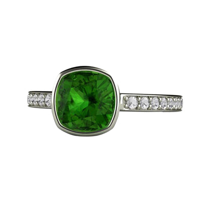 A cushion cut natural Green Tourmaline solitaire ring in a bezel setting with diamond accents in gold or platinum from Rare Earth Jewelry.