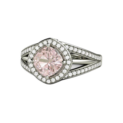 A unique pink sapphire halo engagement ring with a pastel light pink cushion cut pink sapphire center, diamond halo and a triple split shank band in gold or platinum.