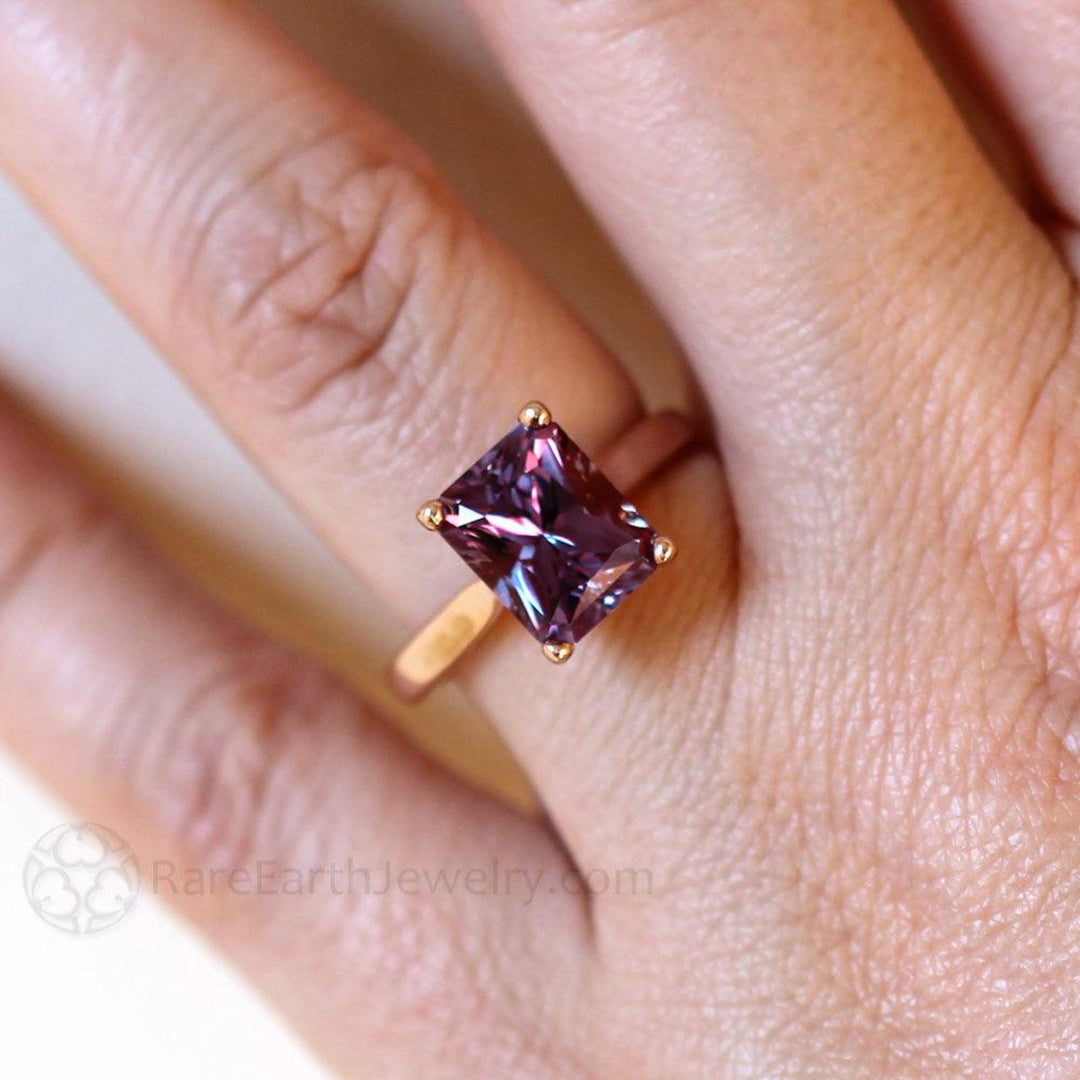 Color Change Sapphire Ring on the Hand, Unique Blue Gemstone turns  Purple and Pink in the Light.  Emerald Cut Sapphire Engagement Ring | Rare Earth Jewelry