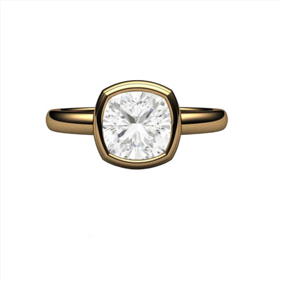 A simple bezel set Moissanite cushion cut solitaire engagement ring with Forever One Moissanite in gold or platinum, shown in yellow gold from Rare Earth Jewelry.