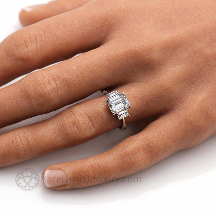 9x7mm Emerald Cut Moissanite Ring on the Finger, 3 Stone Style Colorless Moissanite Engagement Ring | Rare Earth Jewelry