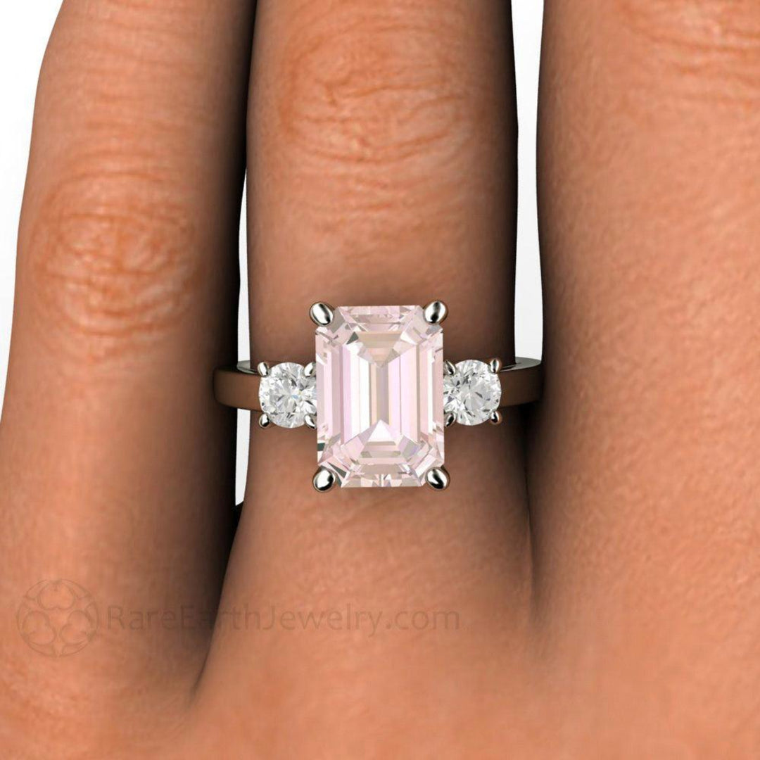 Close up of Emerald Cut Pink Morganite Engagement Ring on the Finger, 3 Stone Style with Diamonds in 14K or 18K Gold | Rare Earth Jewelry