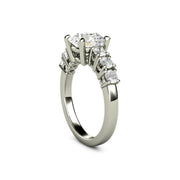 2 carat colorless Moissanite solitaire ring with an 8mm round center stone and six large accent stones on the band in white gold.