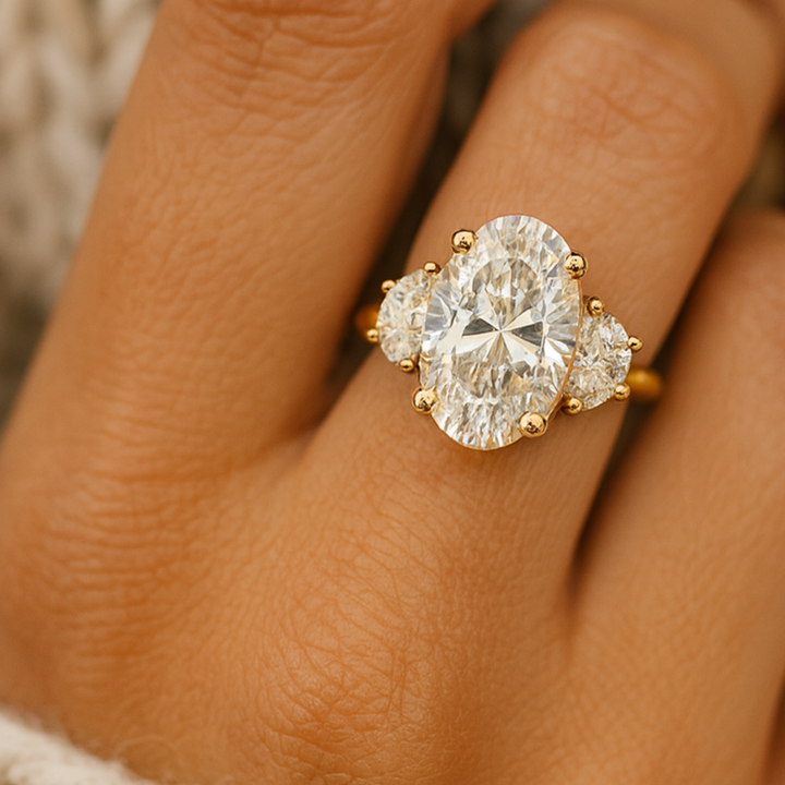 Close up view of 3ct Oval Lab Grown Diamond Engagement Ring on the Finger, Three Stone Design with Half Moons, 5 Carats Total Weight, Elongated Oval Statement Ring | Rare Earth Jewelry