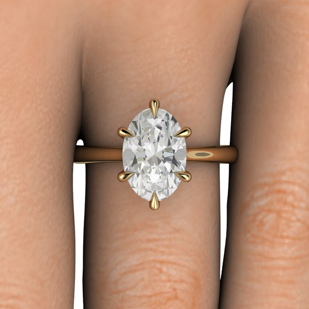 Close up photo of 3ct elongated oval lab grown diamond engagement ring in 14K yellow gold, solitaire with claw prongs - Rare Earth Jewelry