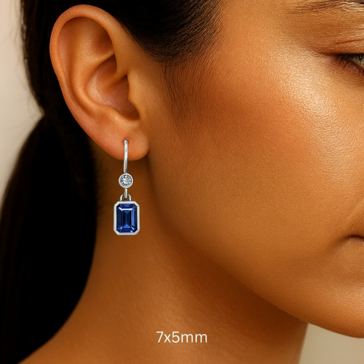 7x5mm Emerald Cut Blue Sapphire Dangle Earrings Shown on a Model, Modern Blue Sapphire and Diamond Earrings, Bezel Set in 14K Gold, 18K or Platinum | Rare Earth Jewelry