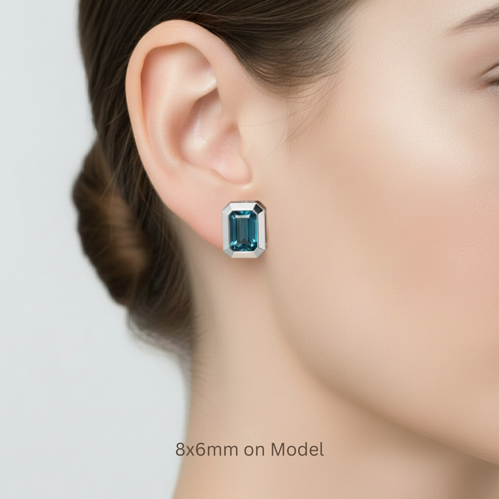 8x6mm London Blue Topaz bezel stud earrings in 14K gold shown on model, bold emerald cut gemstone earrings | Rare Earth Jewelry
