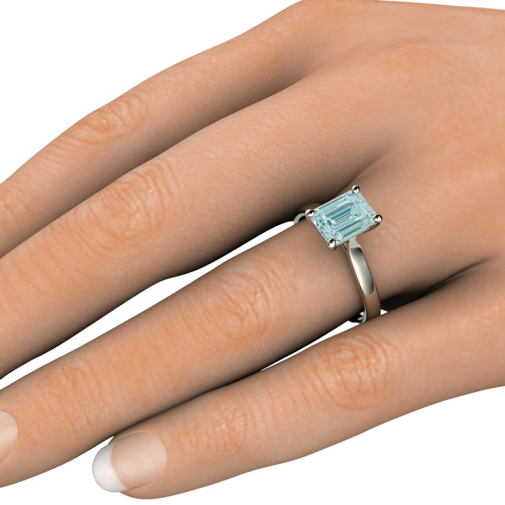 Aquamarine engagement ring emerald cut solitiare 8x6mm on the hand photo from Rare Earth Jewelry.