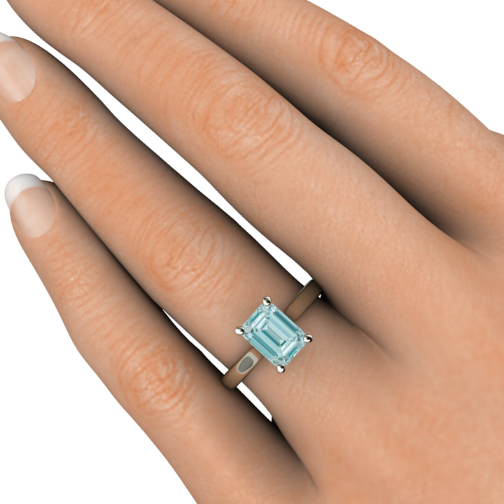 Aquamarine engagement ring emerald cut solitiare on the hand from Rare Earth Jewelry.