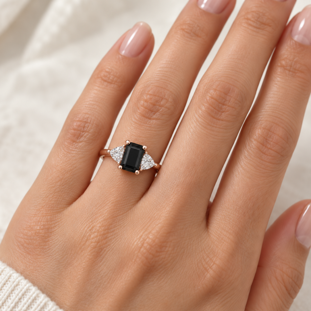 Emerald cut Natural Black Diamond Engagement Ring in a Three Stone Design with Diamond Trillions shown on the Hand | Rare Earth Jewelry