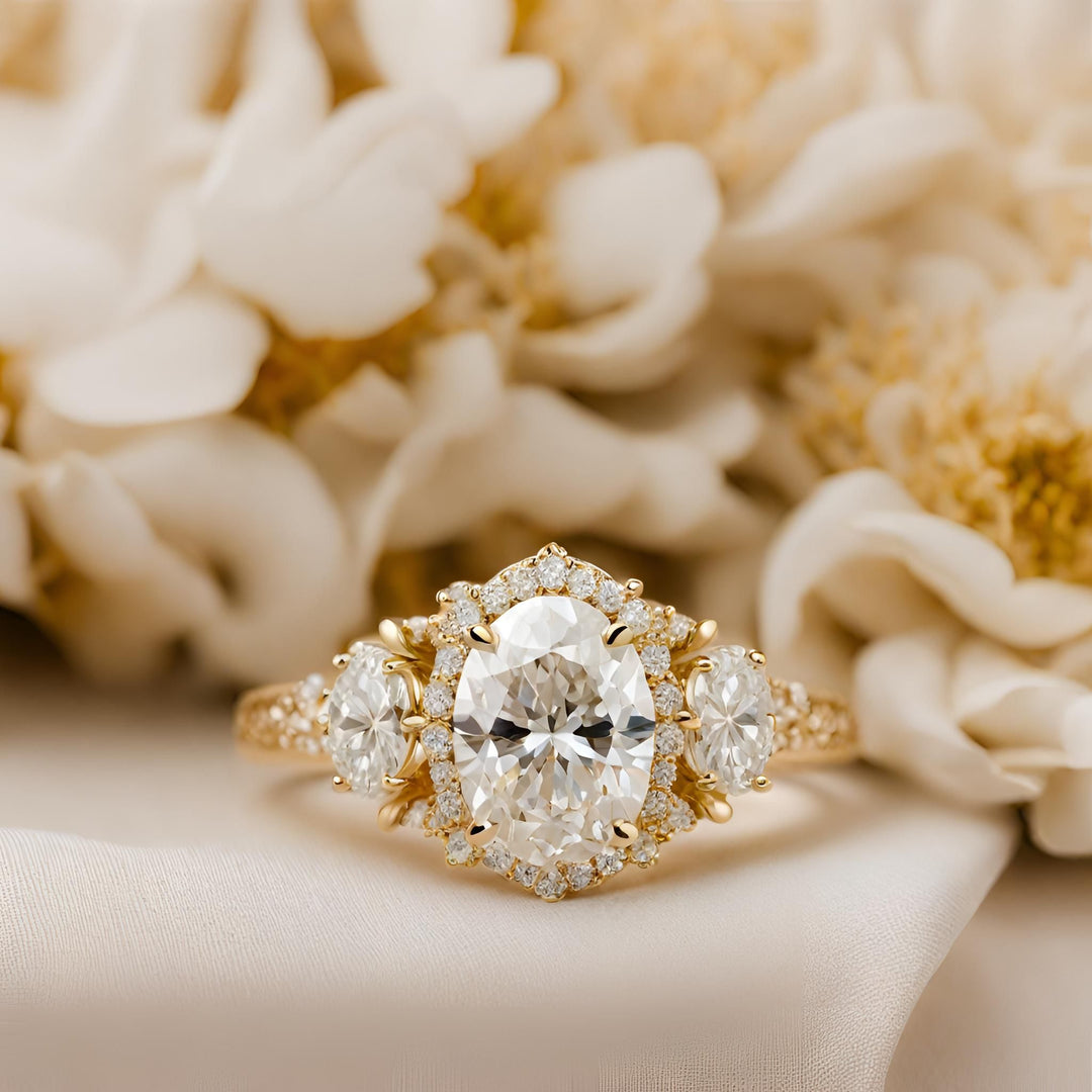 An antique style oval moissanite engagement ring in a 3 stone style with halo from Rare Earth Jewelry.