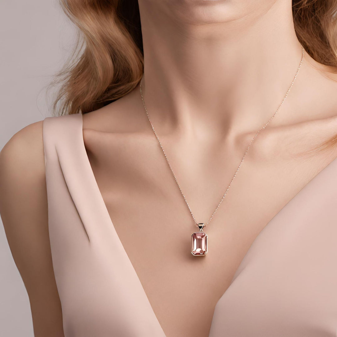 A 14K Rose Gold emerald cut natural Morganite pendant necklace in a sophisticated bezel setting from Rare Earth Jewelry.