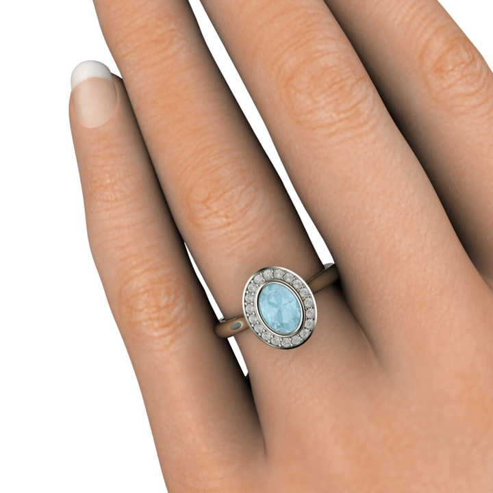 Oval Aquamarine Engagement Ring Bezel Set with Diamond Halo in Gold or Platinum, Natural Aquamarine Ring photo on the hand from Rare Earth Jewelry.