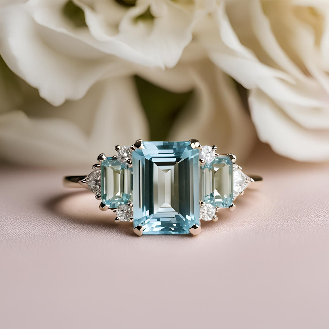 An emerald cut Aquamarine 3 stone engagement ring with diamond accents from Rare Earth Jewelry.