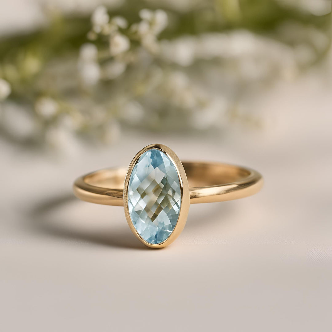 A natural aquamarine marquise cut ring in a modern bezel set solitaire design from Rare Earth Jewelry.