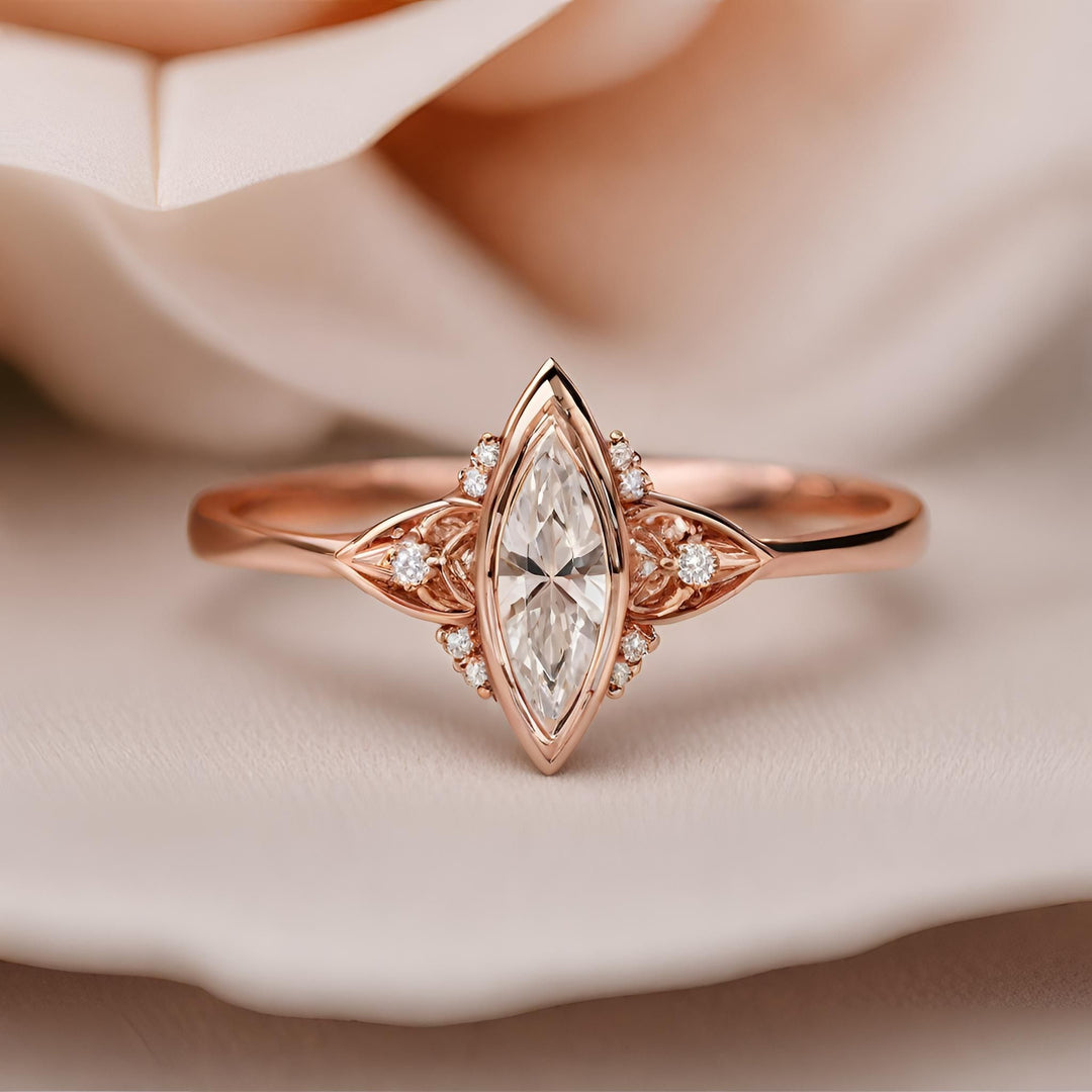 An art deco inspired marquise cut diamond ring with a modern geometric bezel set design in rose gold from Rare Earth Jewelry.