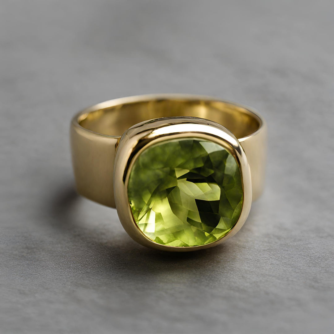 A large Peridot ring, statement ring, right hand ring with a cigar style wide band and bezel set cushion cut peridot from Rare Earth Jewelry.