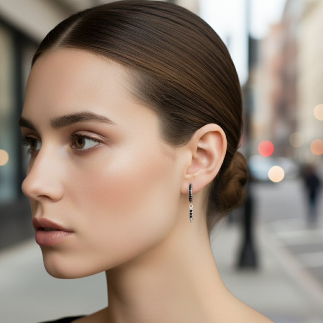 Female model wearing black diamond hoop earring, 14K gold huggie with arrow dangle drop, delicate 20mm spike design, natural black diamonds, modern unisex style | Rare Earth Jewelry