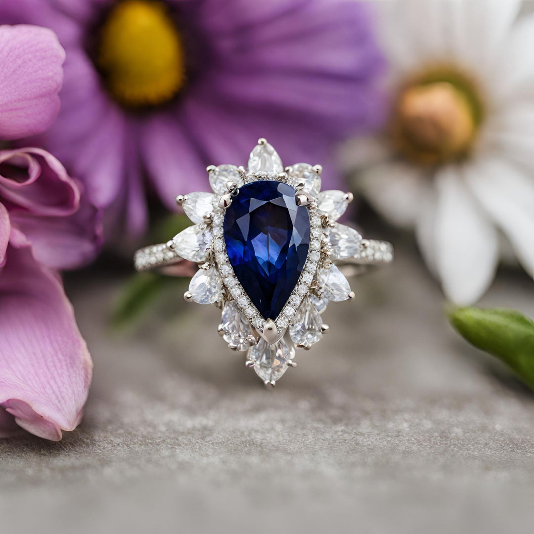 A large blue sapphire pear engagement ring or statement ring in an antique diamond cluster design from Rare Earth Jewelry.