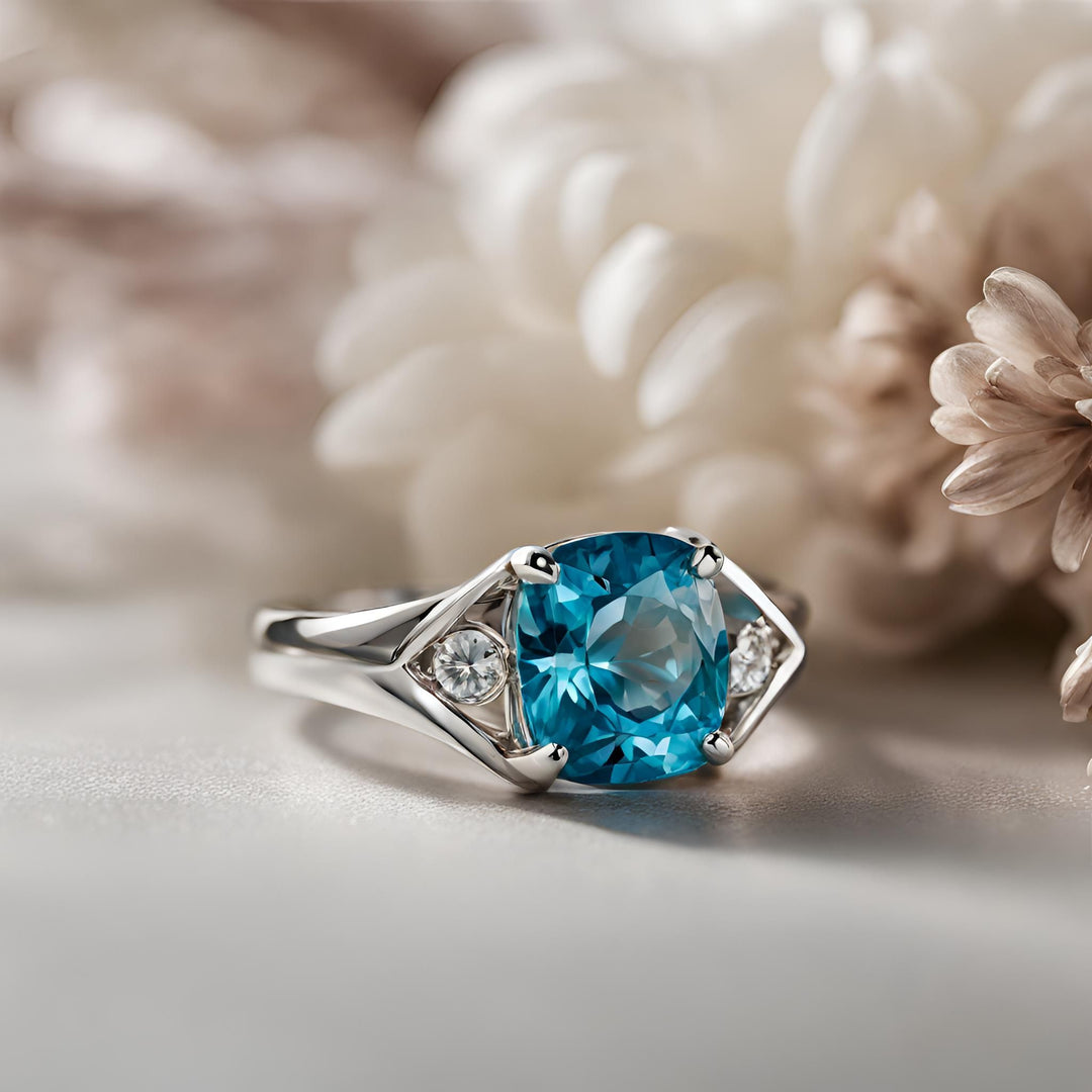 A cushion cut natural blue zircon ring in 14K Gold contemporary 3 stone split shank design from Rare Earth Jewelry.