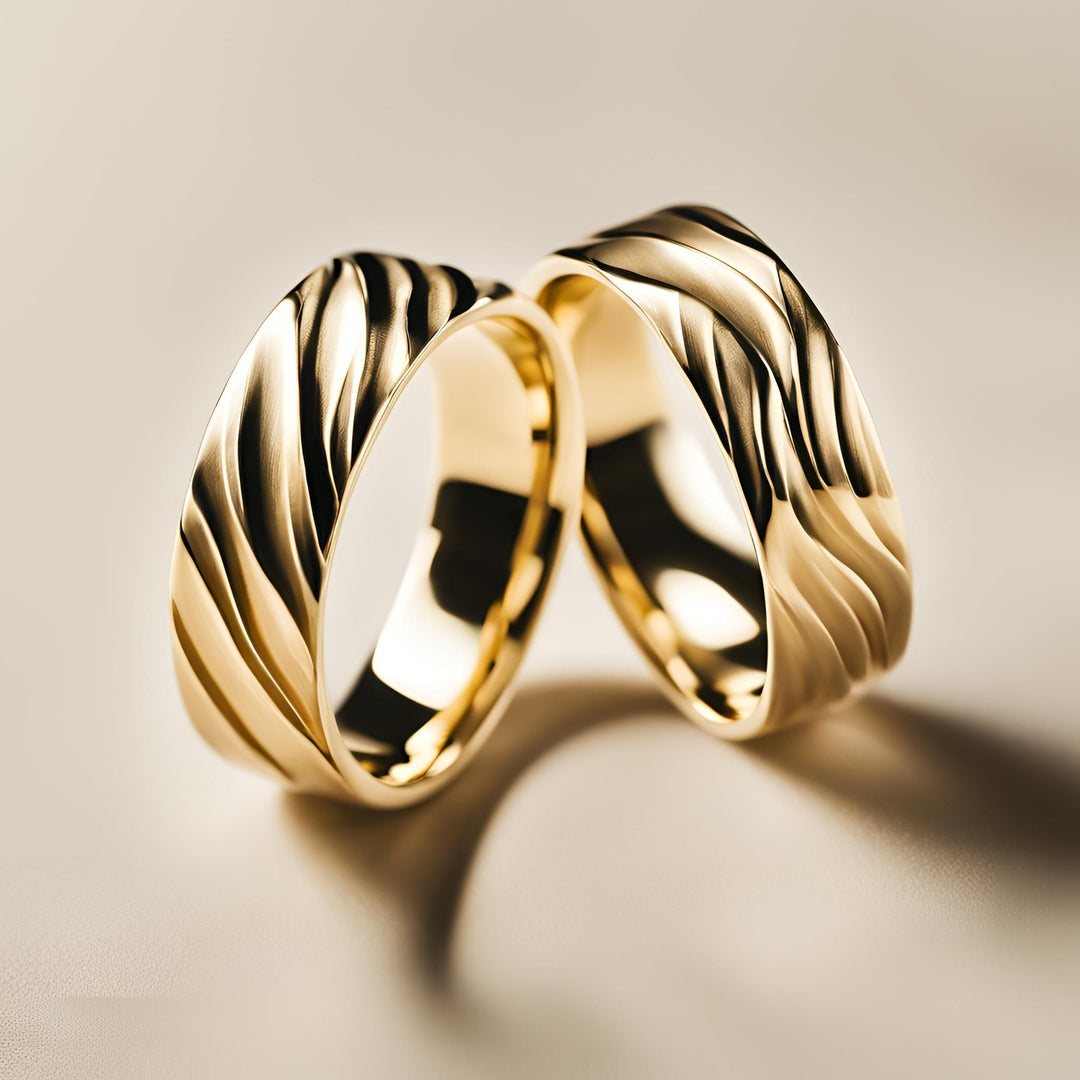 A pair of custom wedding rings with a water wave design in 14K or 18K Gold from Rare Earth Jewelry.