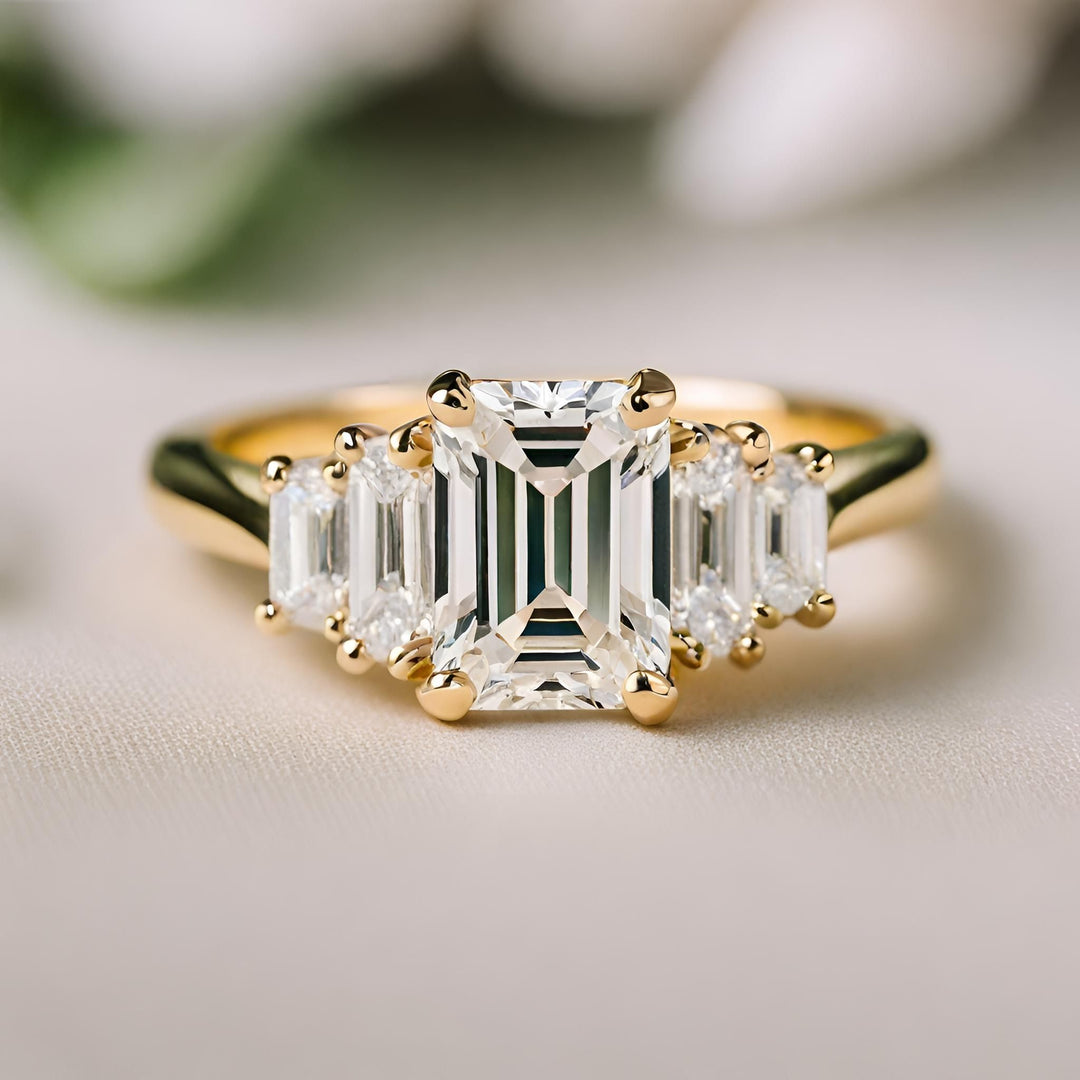 An emerald cut diamond engagement ring with diamond baguettes and a stepped design from Rare Earth Jewelry.