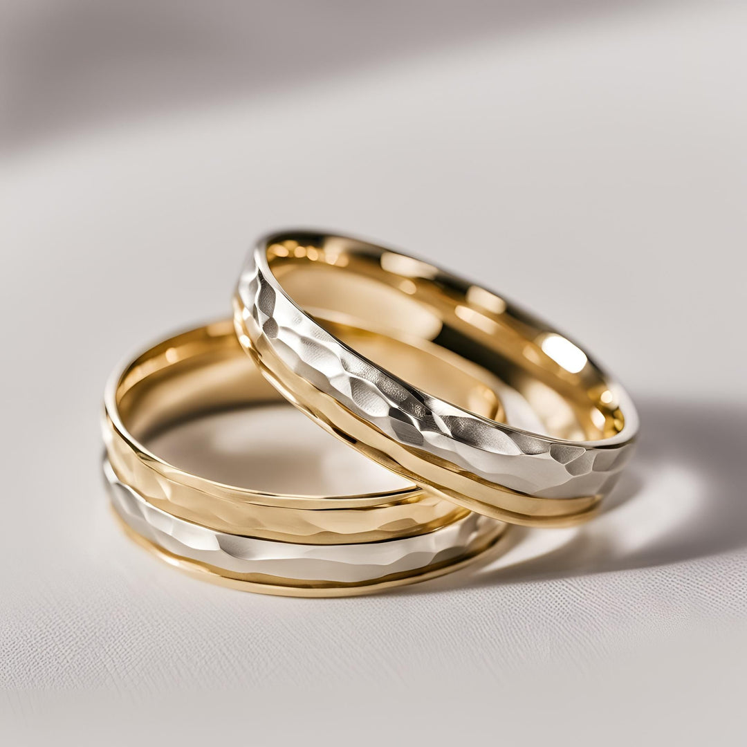 A pair of handmade wedding rings in 2 tone hammered gold from Rare Earth Jewelry.