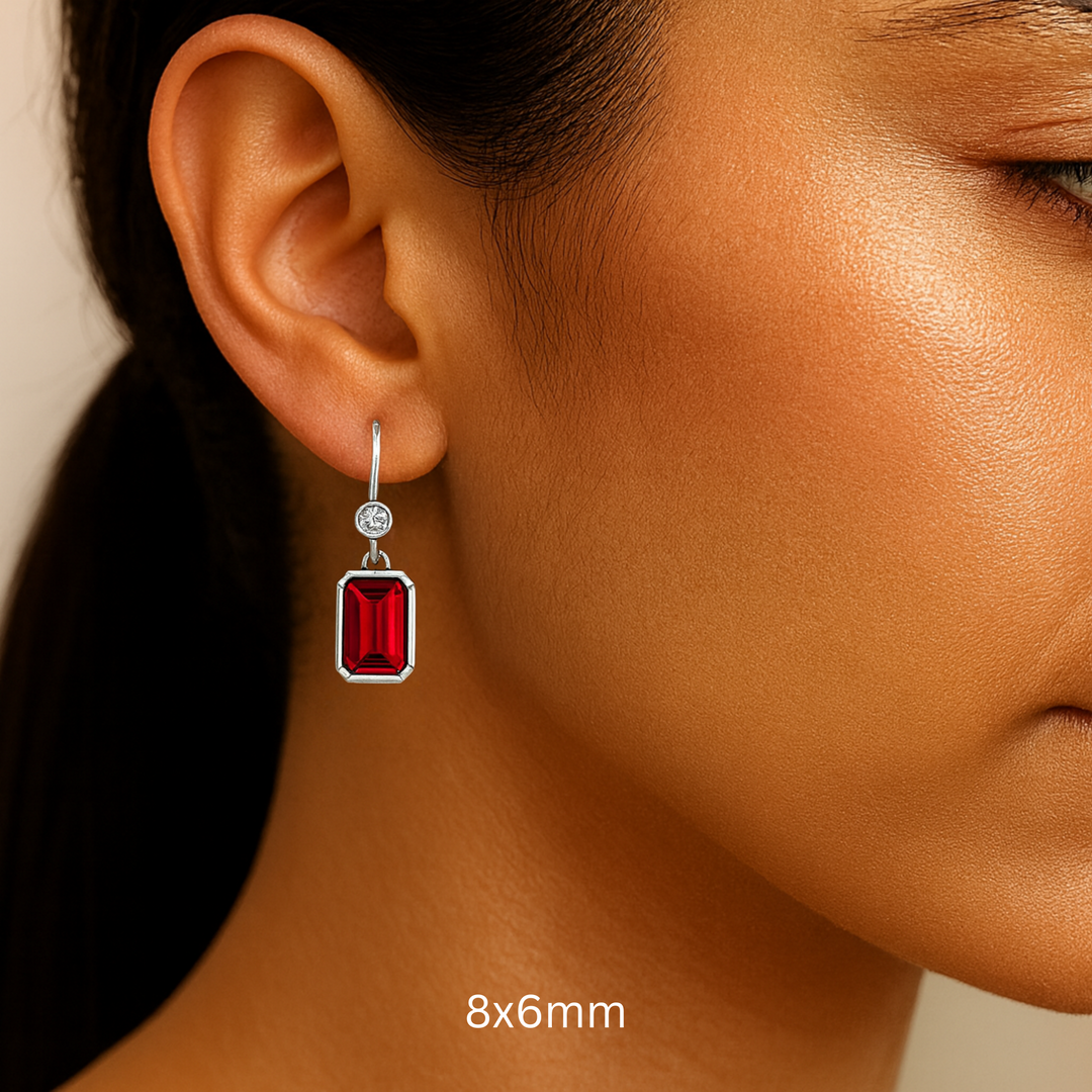 8x6mm Emerald Cut Ruby Earrings with Diamonds shown on the Ear, Bezel Set Ruby Dangle Earrings on French Ear Wires in 14K or 18K Gold and Platinum | Rare Earth Jewelry