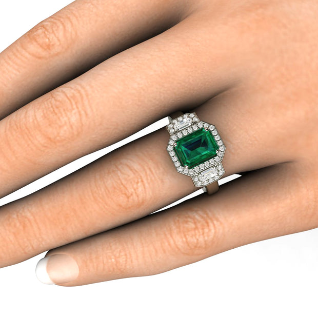 Large lab created chatham emerald ring three stone diamond halo on the hand.