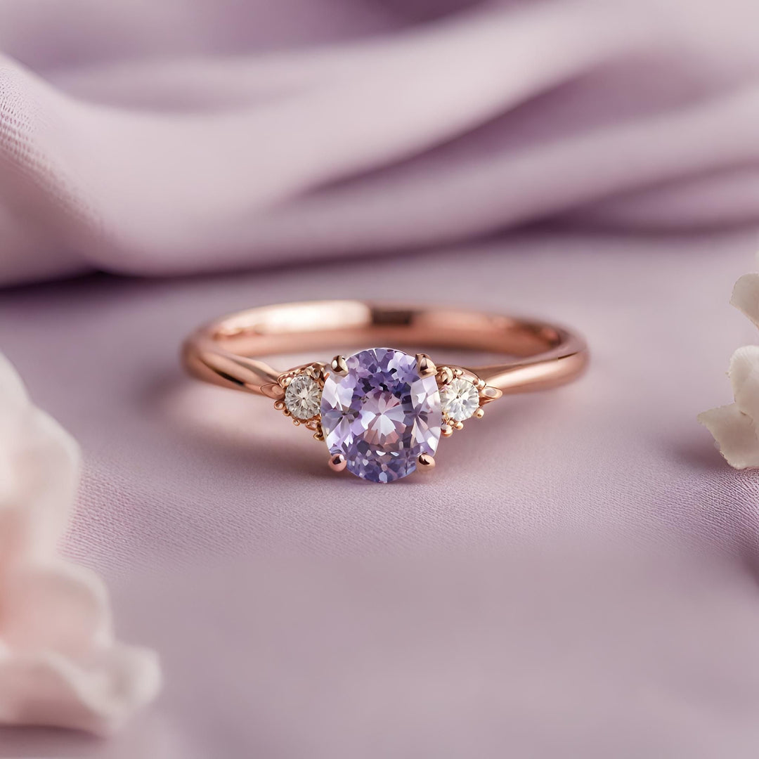 A dainty natural lavender sapphire engagement ring with a cushion cut light purple sapphire from Ceylon and diamonds on a feminine thin band from Rare Earth Jewelry.