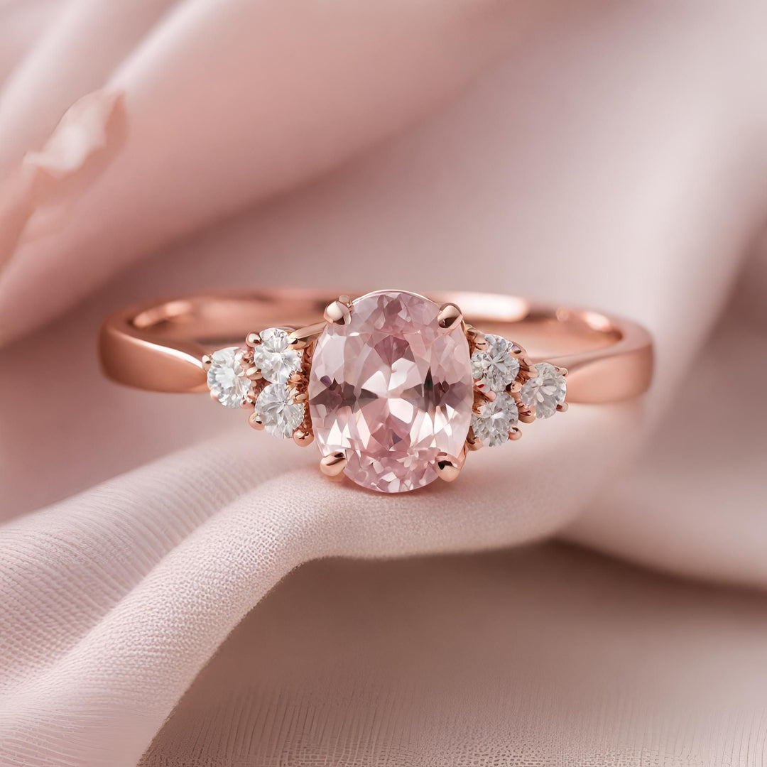 A light pink sapphire oval engagement ring with diamond accents in rose gold from Rare Earth Jewelry.