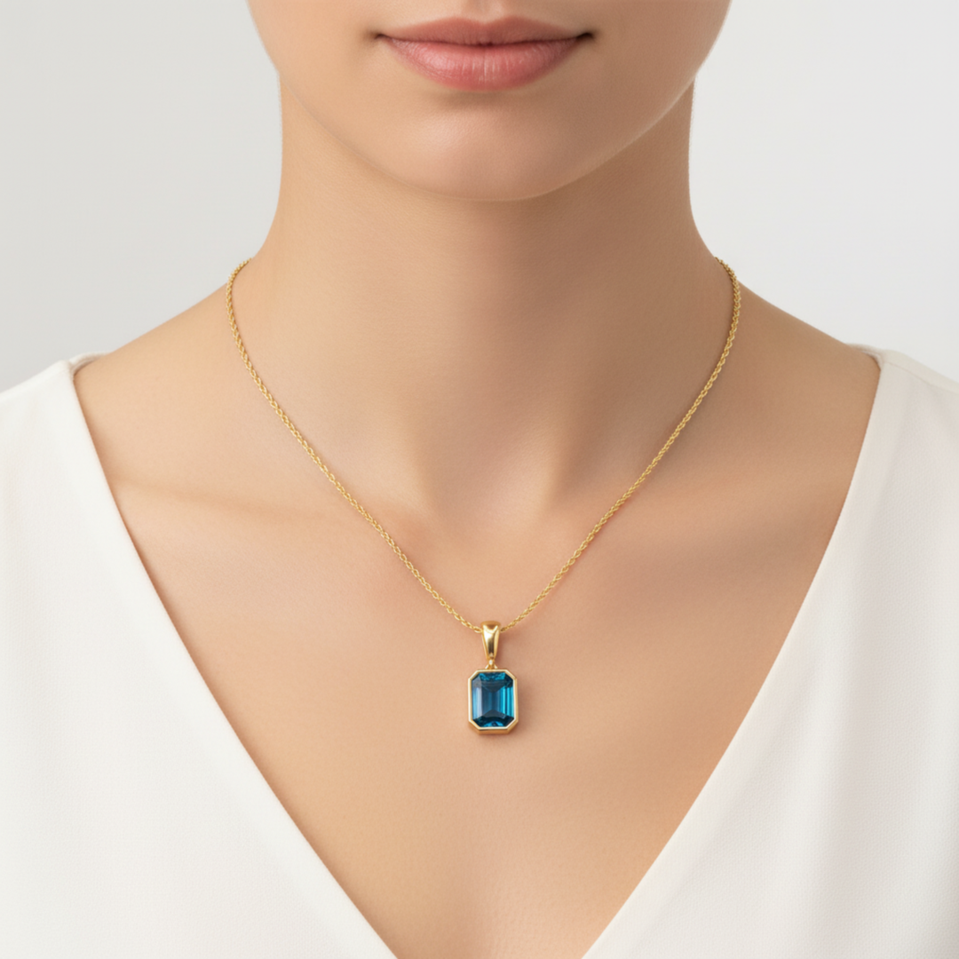 london blue topaz pendant emerald cut bezel set necklace on model in 14k yellow gold | Rare Earth Jewelry