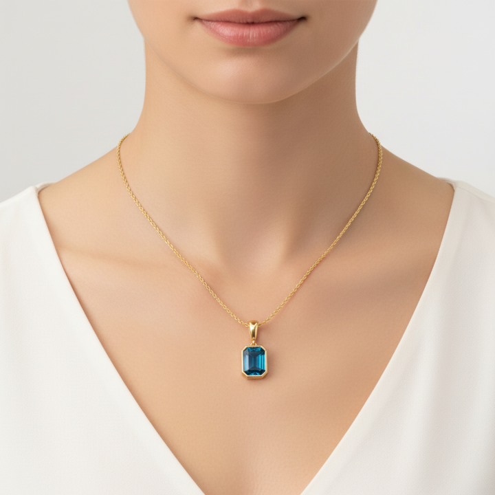 london blue topaz pendant emerald cut bezel set necklace on model in 14k yellow gold | Rare Earth Jewelry