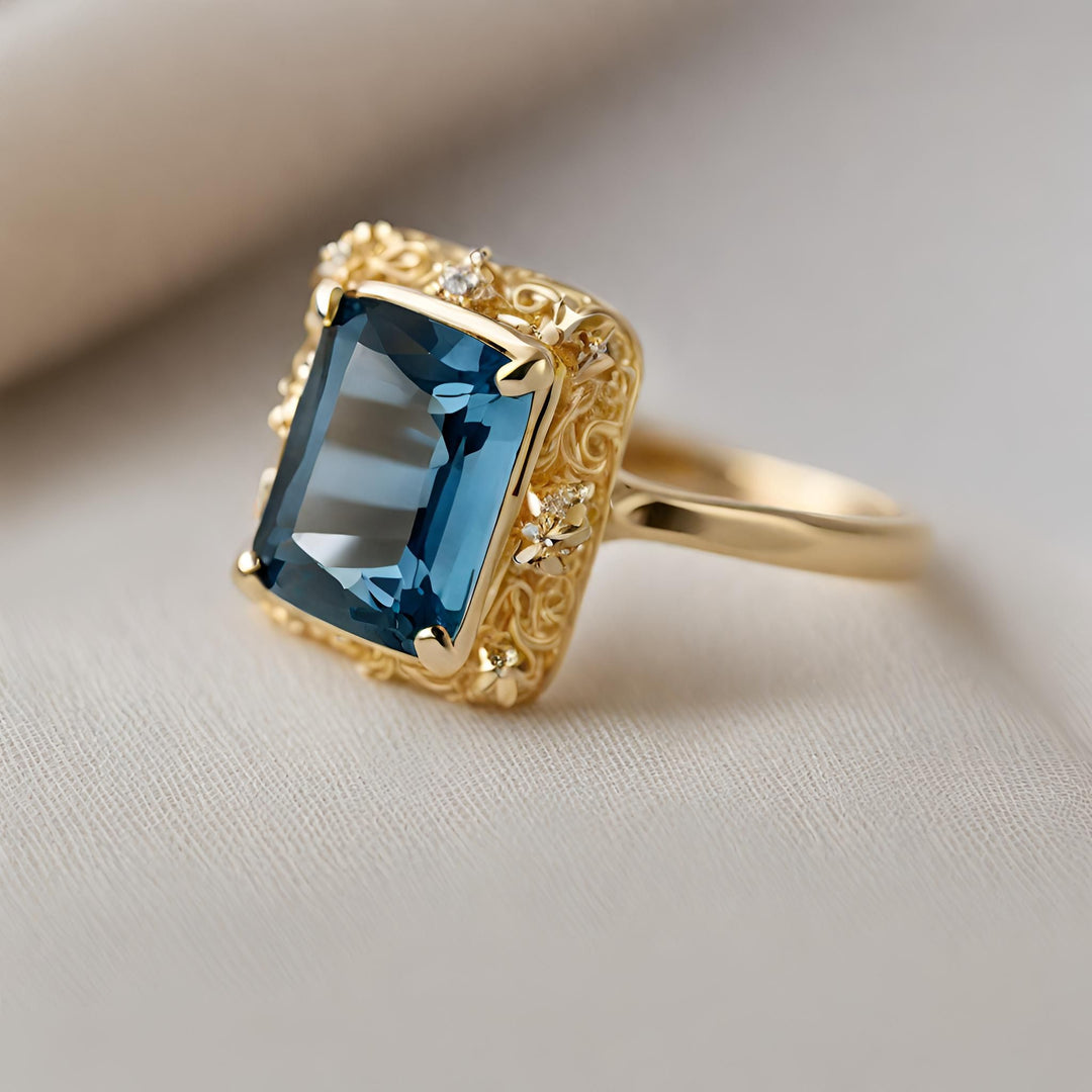 An 18K Gold London Blue Topaz ring with an emerald cut topaz and an antique style with filigree from Rare Earth Jewelry.