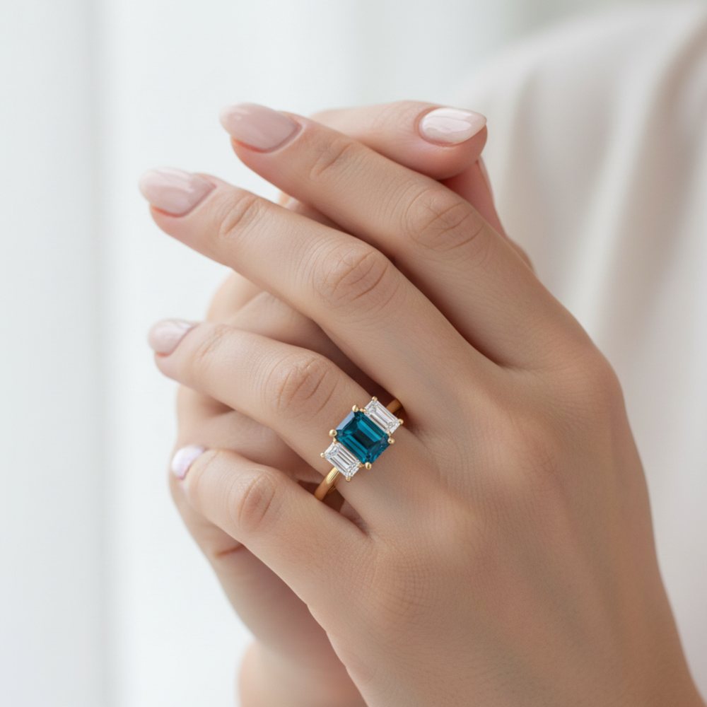 Emerald Cut London Blue Topaz Engagement Ring With Lab Diamond Side Stones On Ring Finger | Rare Earth Jewelry
